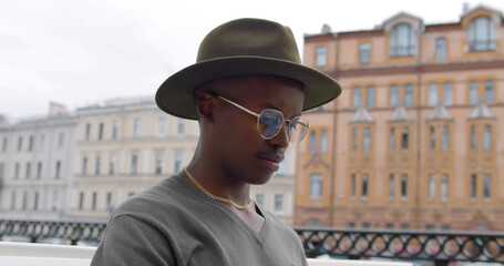 Close up portrait of afro-american hipster freelancer working on laptop outdoors