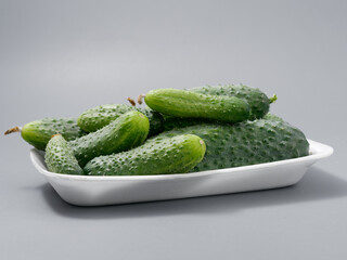 agricultural products green prickly cucumber on gray background