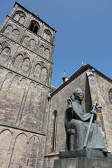 Tower of the Basilica of St Plechelm (Sint-Plechelmusbasiliek) built of Bentheimer sandstone in the dutch city of Oldenzaal with statue of Plechelmus in front