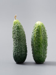 agricultural products green prickly cucumber on gray background