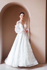 Fototapeta premium Smiling young woman posing in a wedding dress