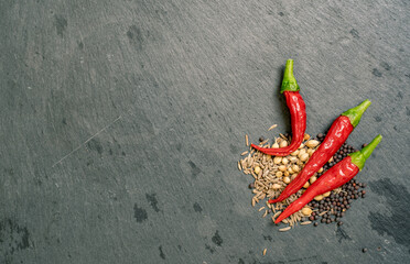 Spices and Chilli Peppers on Black Slate Tile