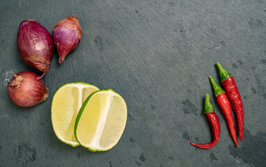 Lime, Shallots and Chilli Peppers on Black Slate Tile
