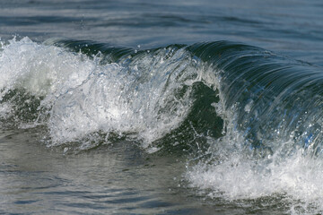 Wasserwellen mit weißer Gischt, brechen im flachen Wasser der Ostsee.
