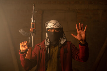 Militant or Gangster with face cover and gun in hand surrendering by putting hands up. - obrazy, fototapety, plakaty