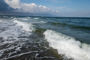 Wasserwellen mit weißer Gischt, brechen im flachen Wasser der Ostsee.