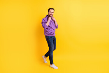 Fototapeta na wymiar Full size profile side photo of young man happy positive smile go meeting fix hoodie isolated over yellow color background