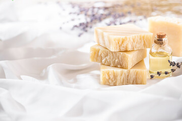 Fototapeta na wymiar Natural handmade soap with lavender flowers on white silk. Aromatic natural soap. Organic soap.