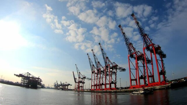 Timelapse shot of the Elbe river, huge harbour cranes and boat in Hamburg, Germany