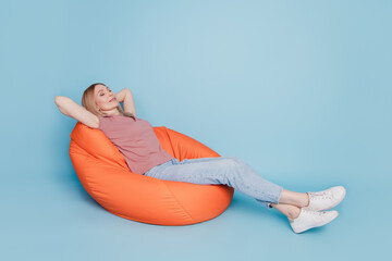 Photo portrait full body view of sitting in orange bean bag chair rest relax sleep nap time...