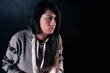 Beautiful woman sitting on a bench thinking and finishing training. Isolated on black background.