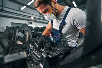 Repairman checking spare part condition with wrench