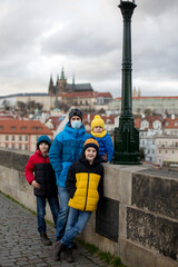 Happy family with children on a Charles bridge wintertime in Prague, Czech