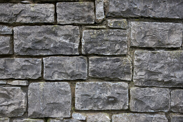 Textured stone wall background. Square patterns on an old grey wall