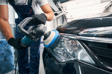 Man making headlight clean with polishing machine