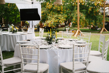 Wedding tables under the marquee decorated with floral decorations