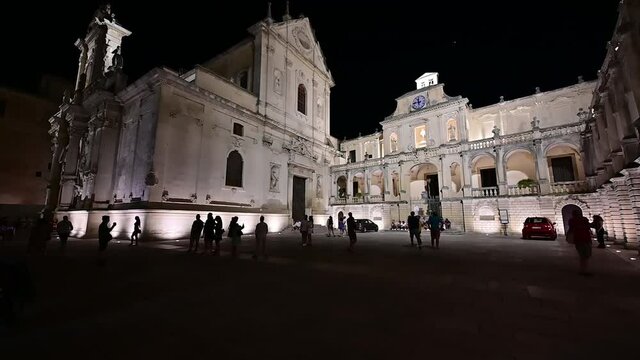 Lecce, Puglia, Italy. August 2021. Amazing night footage of the cathedral square in slow motion. The nocturnal atmosphere is captured in the slow movement of the people who populate the square.
