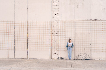Fototapeta na wymiar Beautiful young casual woman leaning on wall isolated