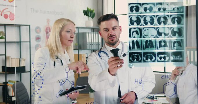 Medicine concept where attractive successful experienced male and female doctors working together in medical lab and discussing patient's x-ray