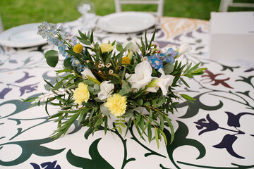Wedding table for guests, decorated with floral decoration, white plates