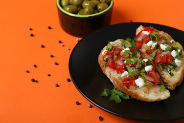 Delicious italian snacks bruschetta and ingredients on orange background
