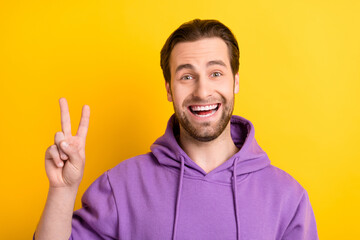 Photo of young guy happy positive smile show peace cool -sign isolated over yellow color background