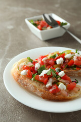Plate with bruschetta snacks on gray textured table