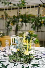 Decorated wedding guest table, floral decor and candles, white chairs