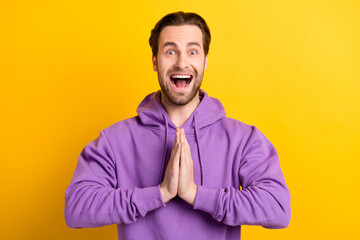 Photo of lucky crazy guy hold hands plead request open mouth wear violet sweatshirt isolated yellow...
