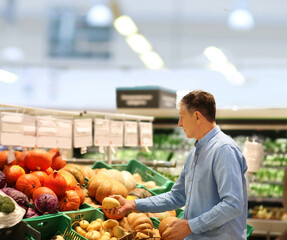 Fototapeta premium Senior Man Choosing groceries, vegetables, fruits in the supermarket