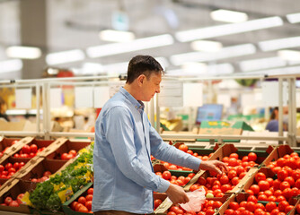 Senior Man Choosing  groceries, vegetables, fruits in the supermarket