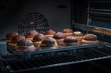 Baking process of chocolate muffins in oven, home made. Sweet cupcakes with cocoa baked in oven.