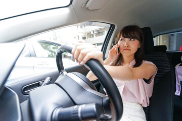 スマホを使いながら運転する女性