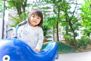 Fototapeta na wymiar 公園で一人で遊ぶ子ども