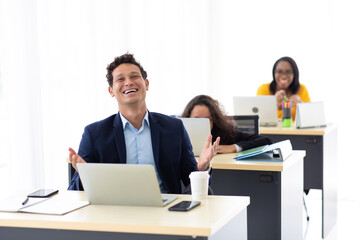 Young hispanic man sitting drink coffee and working on laptop computer at creative home office.