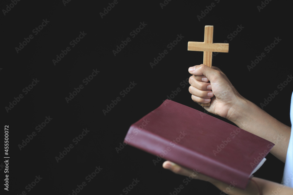 Wall mural Woman praying while holding Bible and cross, Pray in the Morning , Woman praying with hands together on the Sunrise background. - Wall murals