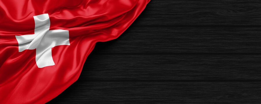 Close Up of Switzerland flag on the black wooden background 3D render