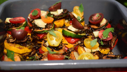 Gemüsegericht mit Zucchini, Tomaten, Basilikum Oregano in Türmchen, veganes Essen