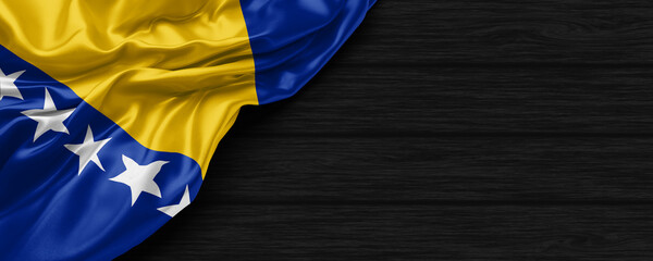 Close Up of Bosnian flag on the black wooden background 3D render