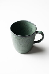 Vertical of green pottery green coffee cup isolated on white 