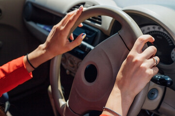 A young woman is sitting at the wheel of a car. Transport management.The theme of traveling by car.