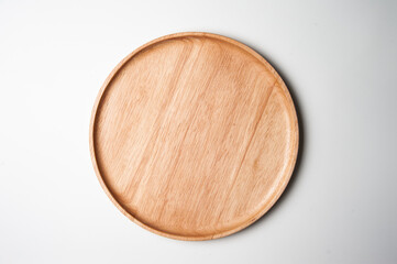 Top view of round and wooden plate on white background