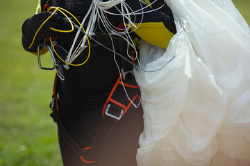 Exhaust ring with cable and reserve parachute canopy in the hands of a skydiver, close-up, face not...