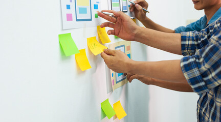 Business creative team work together, mobile application software design project. Two app designers design and draw the layout of mobile applications.