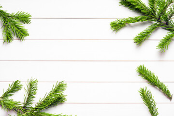 Fototapeta na wymiar Green spruce tree branches on white wooden. Christmas New Year background, top view. Place for your text