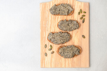 Probiotic-Cultured Vegan Cheese Paste made from pumpkin seeds spread on top of bread slices, top view with copy space