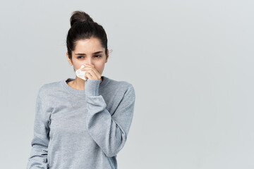 woman in gray sweater wipes her face with a handkerchief health problems