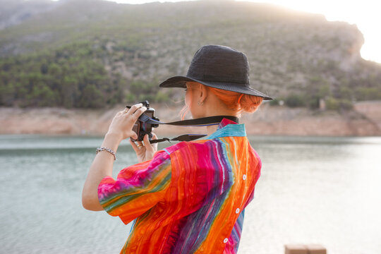 Woman in a lake taking pictures of the landscape
