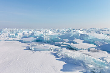 Beautiful winter landscape of frozen Lake Baikal. Endless snow-covered field with transparent blue...