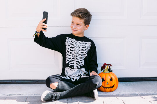 Kid in Halloween outfit taking selfie